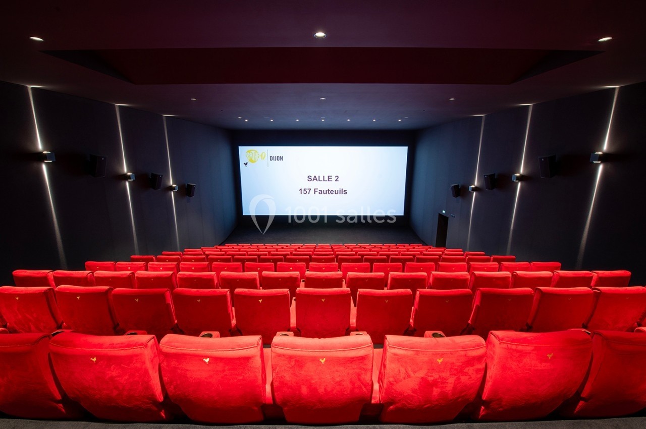Salle de cinéma vide avec des rangées de fauteuils rouges et un écran affichant ’Salle 2 - 157 Fauteuils’.