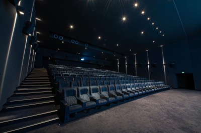Salle de cinéma moderne avec écran large, sièges rouges et éclairage tamisé, affichant ’Pathé Dijon, Salle 9, 85 fauteuils’.