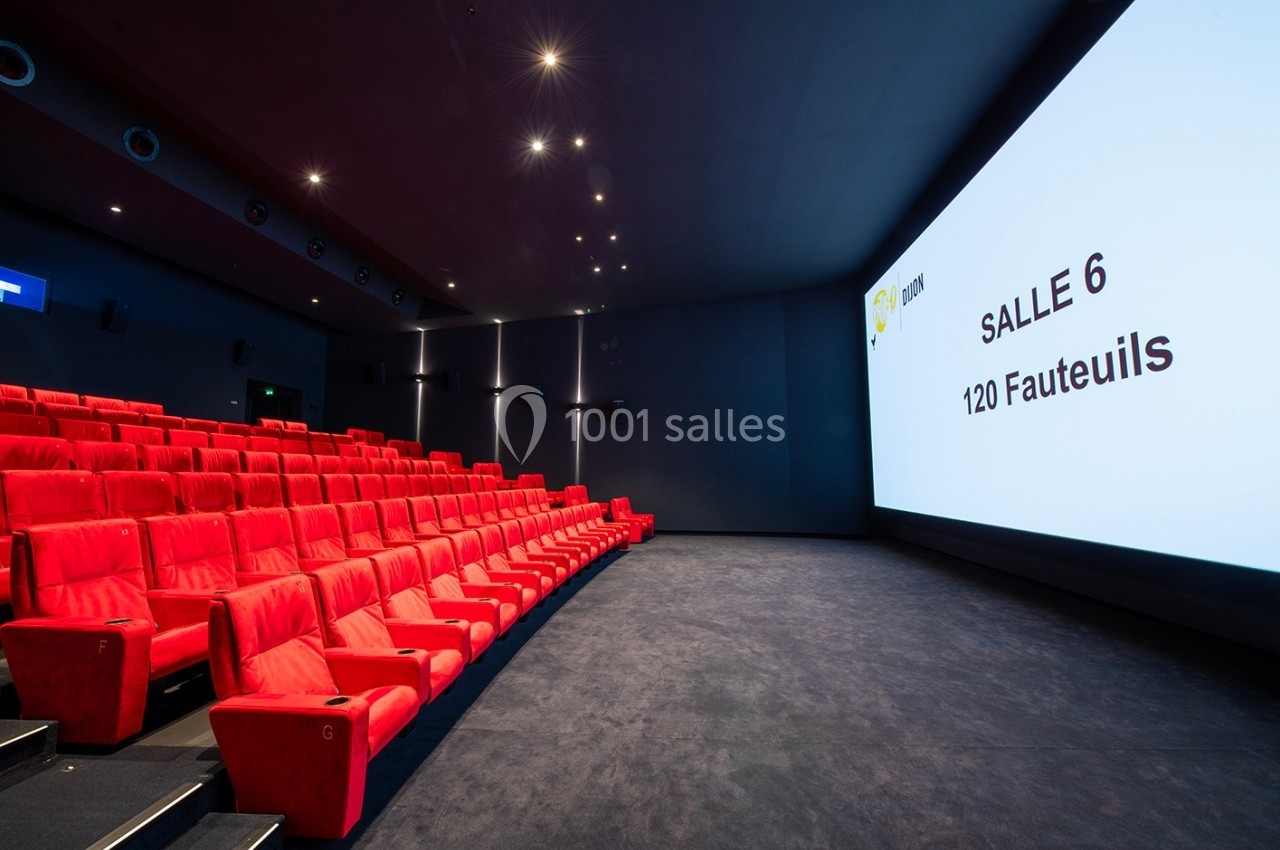 Salle de cinéma moderne avec des fauteuils rouges alignés et un écran affichant ’Salle 6 - 120 Fauteuils’.