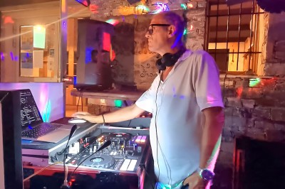 Miniature DJ Ventiseri (Haute-Corse) - Philippe DJ Son et Lumières #5 Un DJ mixe de la musique sur une console dans un espace extérieur éclairé par des lumières colorées.