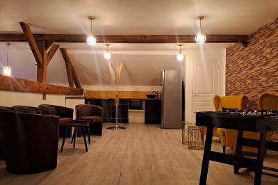 Miniature Location salle Vert-Saint-Denis (Seine-et-Marne) - Lebaron84 #3 Studio éclairé en violet avec un canapé, une table basse et des coussins au sol, logo Netflix projeté sur le mur.