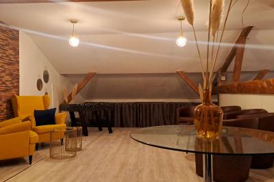 Miniature Location salle Vert-Saint-Denis (Seine-et-Marne) - Lebaron84 #7 Studio éclairé en violet avec un canapé, une table basse et des coussins au sol, logo Netflix projeté sur le mur.