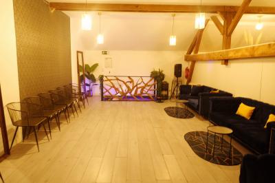 Miniature Location salle Vert-Saint-Denis (Seine-et-Marne) - Lebaron84 #4 Studio éclairé en violet avec un canapé, une table basse et des coussins au sol, logo Netflix projeté sur le mur.