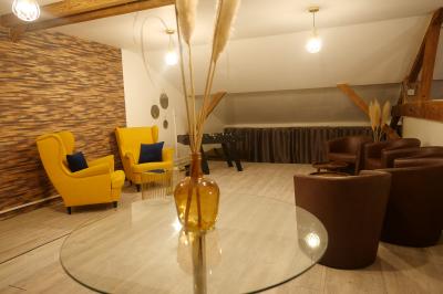 Miniature Location salle Vert-Saint-Denis (Seine-et-Marne) - Lebaron84 #14 Studio éclairé en violet avec un canapé, une table basse et des coussins au sol, logo Netflix projeté sur le mur.