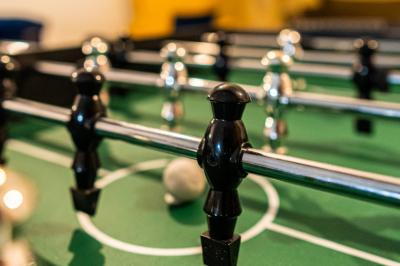 Miniature BABY-FOOT Studio éclairé en violet avec un canapé, une table basse et des coussins au sol, logo Netflix projeté sur le mur.