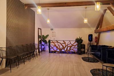 Miniature SALLE Studio éclairé en violet avec un canapé, une table basse et des coussins au sol, logo Netflix projeté sur le mur.