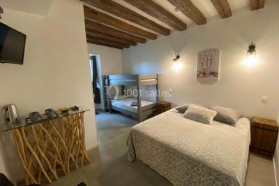 Chambre avec lit double, douche accessible, sol en parquet clair et éclairage moderne.