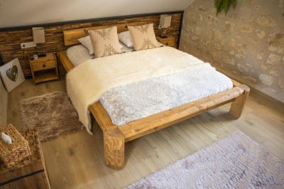 Chambre avec lit double, douche accessible, sol en parquet clair et éclairage moderne.