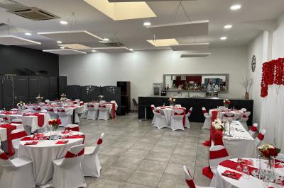 Comptoir de bar avec bouteilles alignées, verres, machine à café et décor sobre dans une pièce lumineuse.