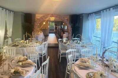 Un parc verdoyant avec des arbres feuillus et une allée ensoleillée menant à un bâtiment blanc au loin.