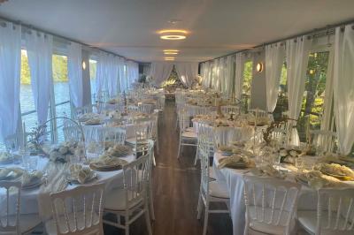 Un parc verdoyant avec des arbres feuillus et une allée ensoleillée menant à un bâtiment blanc au loin.