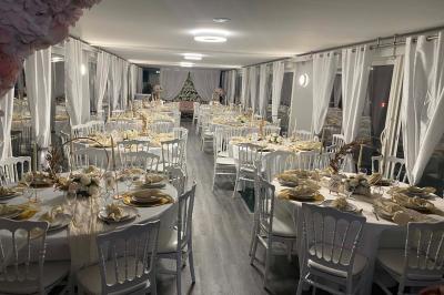 Un parc verdoyant avec des arbres feuillus et une allée ensoleillée menant à un bâtiment blanc au loin.