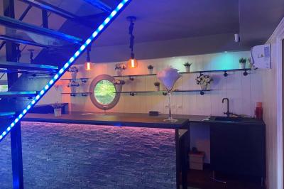 Un parc verdoyant avec des arbres feuillus et une allée ensoleillée menant à un bâtiment blanc au loin.