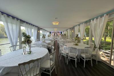 Un parc verdoyant avec des arbres feuillus et une allée ensoleillée menant à un bâtiment blanc au loin.