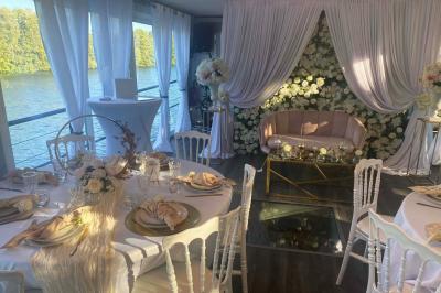 Un parc verdoyant avec des arbres feuillus et une allée ensoleillée menant à un bâtiment blanc au loin.