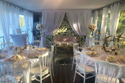 Un parc verdoyant avec des arbres feuillus et une allée ensoleillée menant à un bâtiment blanc au loin.