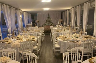 Un parc verdoyant avec des arbres feuillus et une allée ensoleillée menant à un bâtiment blanc au loin.
