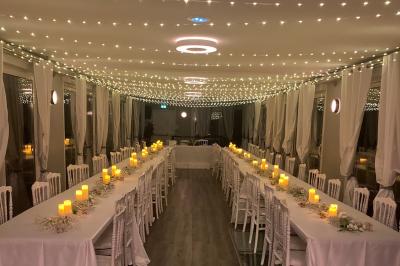 Un parc verdoyant avec des arbres feuillus et une allée ensoleillée menant à un bâtiment blanc au loin.