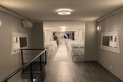 Un parc verdoyant avec des arbres feuillus et une allée ensoleillée menant à un bâtiment blanc au loin.