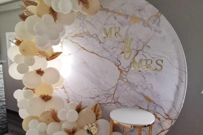 Un parc verdoyant avec des arbres feuillus et une allée ensoleillée menant à un bâtiment blanc au loin.