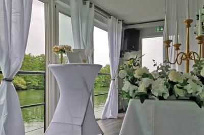 Un parc verdoyant avec des arbres feuillus et une allée ensoleillée menant à un bâtiment blanc au loin.