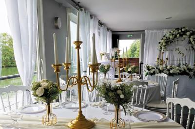 Un parc verdoyant avec des arbres feuillus et une allée ensoleillée menant à un bâtiment blanc au loin.