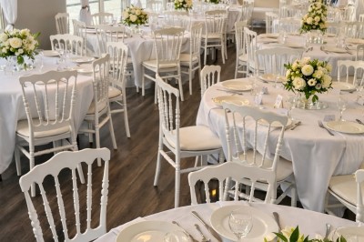 Miniature Location salle Jouy-le-Moutier (Val-d'Oise) - Le Yacht #57 Table élégamment dressée avec nappes blanches, serviettes pliées, verres et décorations florales dans une salle lumineuse.