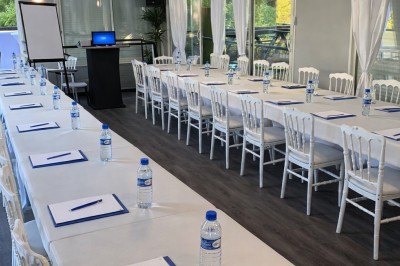 Miniature Location salle Jouy-le-Moutier (Val-d'Oise) - Le Yacht #59 Table élégamment dressée avec nappes blanches, serviettes pliées, verres et décorations florales dans une salle lumineuse.