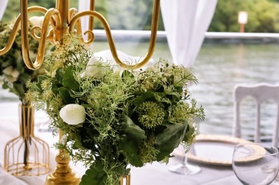 Miniature Location salle Jouy-le-Moutier (Val-d'Oise) - Le Yacht #60 Table élégamment dressée avec nappes blanches, serviettes pliées, verres et décorations florales dans une salle lumineuse.