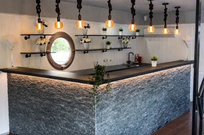 Miniature Location salle Jouy-le-Moutier (Val-d'Oise) - Le Yacht #5 Table élégamment dressée avec nappes blanches, serviettes pliées, verres et décorations florales dans une salle lumineuse.