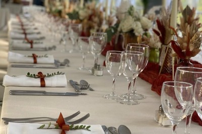 Miniature Location salle Jouy-le-Moutier (Val-d'Oise) - Le Yacht #68 Table élégamment dressée avec nappes blanches, serviettes pliées, verres et décorations florales dans une salle lumineuse.