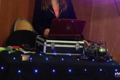Un couple danse dans une salle faiblement éclairée avec des lumières colorées et une ambiance festive.