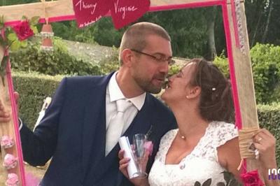 Un couple danse dans une salle faiblement éclairée avec des lumières colorées et une ambiance festive.