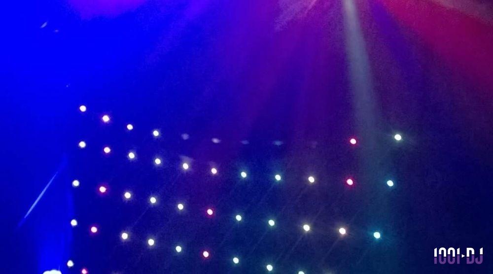 Jeu de lumières colorées sur une scène sombre, avec des projecteurs rouges, bleus et blancs.