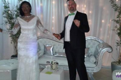 Un couple danse dans une salle faiblement éclairée avec des lumières colorées et une ambiance festive.