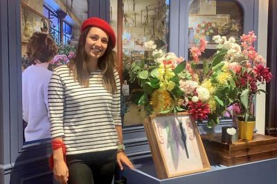 Quatre femmes en robe noire sourient debout sur une terrasse en bois avec un fond de verdure.