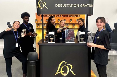 Quatre femmes en robe noire sourient debout sur une terrasse en bois avec un fond de verdure.