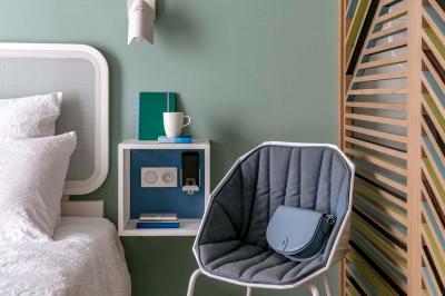 Lavabo moderne avec miroir rond, étagère murale, robinet chromé et panneaux en bois ajourés en premier plan.