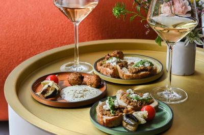 Lavabo moderne avec miroir rond, étagère murale, robinet chromé et panneaux en bois ajourés en premier plan.