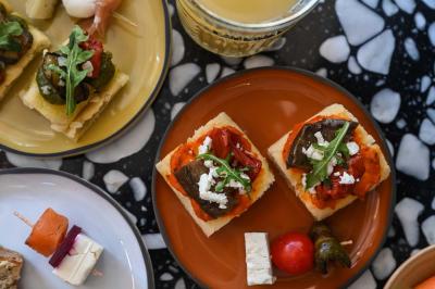 Lavabo moderne avec miroir rond, étagère murale, robinet chromé et panneaux en bois ajourés en premier plan.