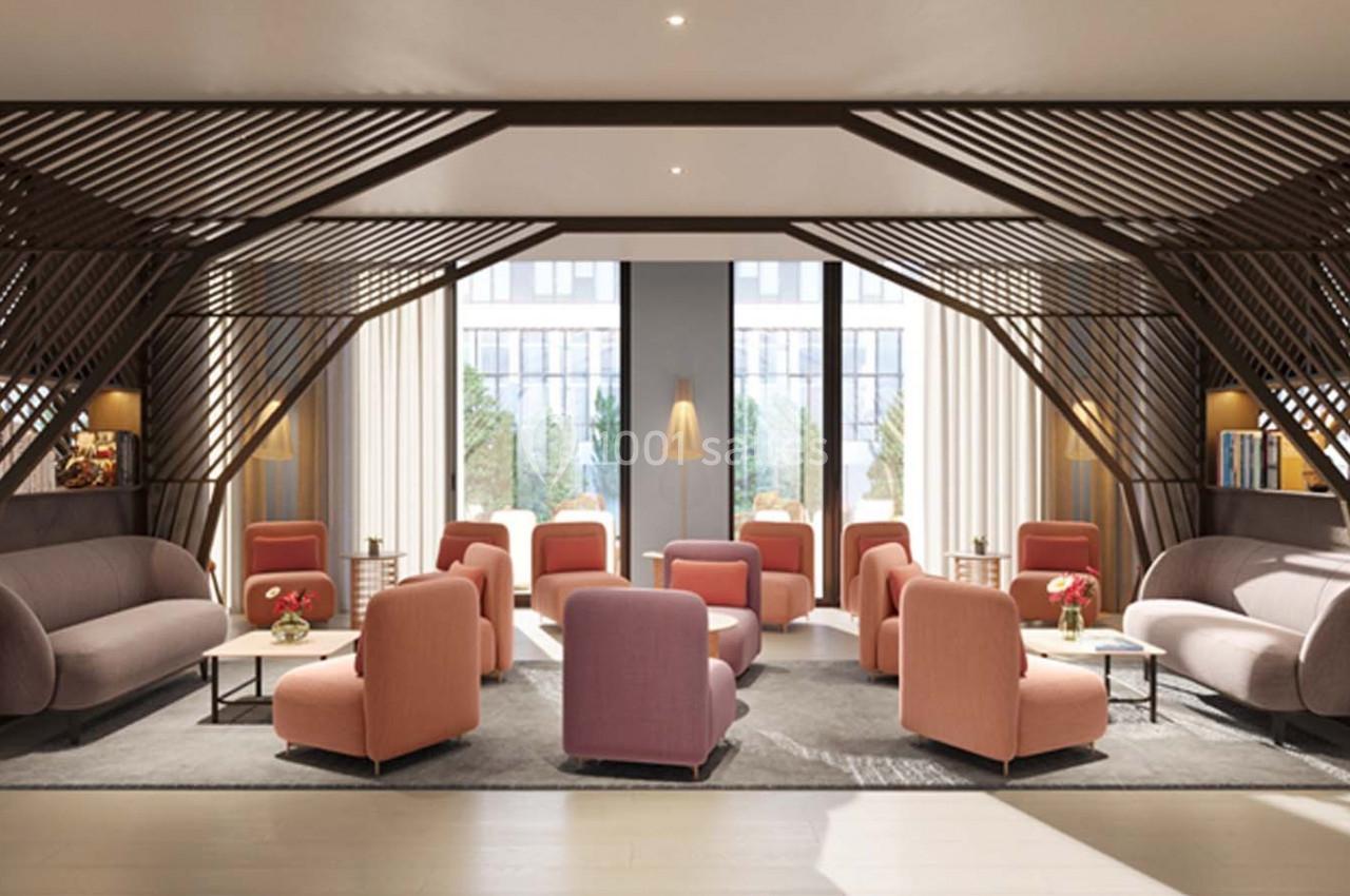 Espace lounge moderne avec fauteuils roses, canapés gris, tables basses et grandes fenêtres laissant entrer la lumière…