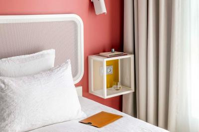 Lavabo moderne avec miroir rond, étagère murale, robinet chromé et panneaux en bois ajourés en premier plan.