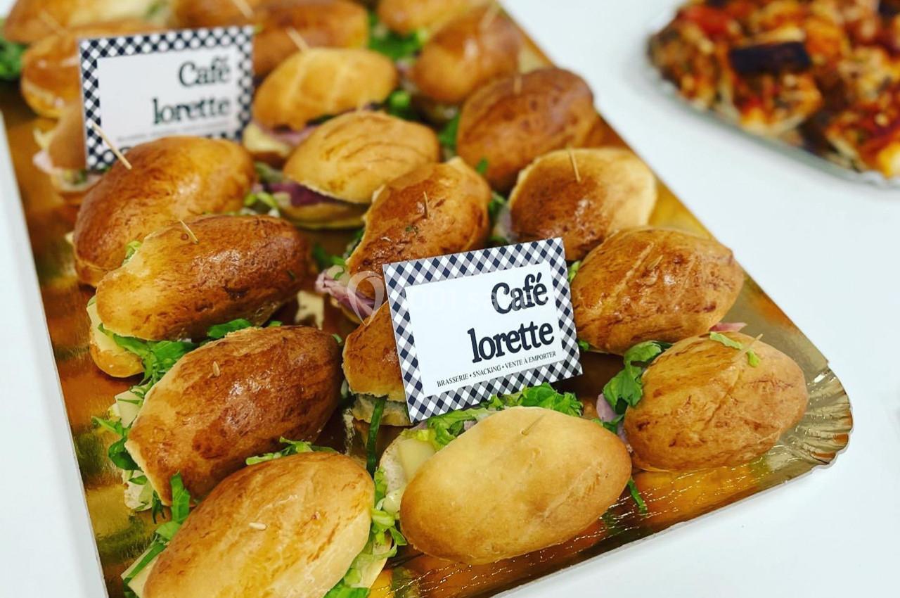 Plateau de petits sandwichs garnis de salade et de charcuterie, disposés sur un plateau doré.