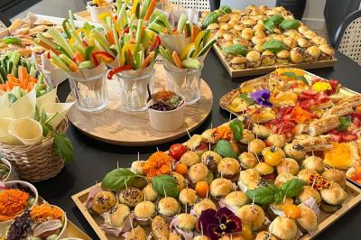 Plateau de légumes frais comprenant chou-fleur, tomates cerises, céleri, radis et feuilles vertes.