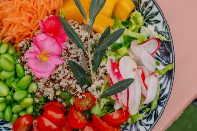 Plateau de légumes frais comprenant chou-fleur, tomates cerises, céleri, radis et feuilles vertes.