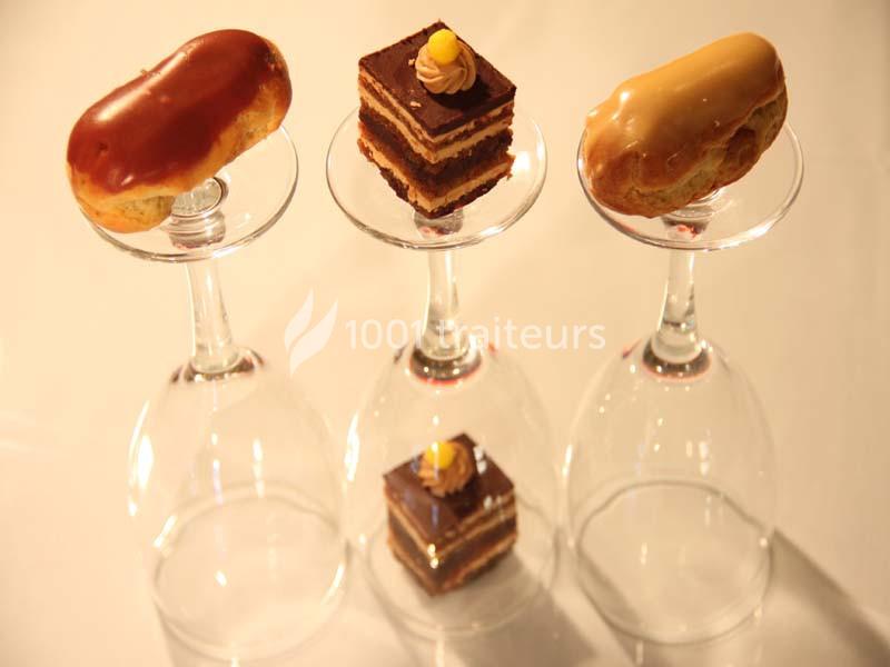 Desserts élégants, dont éclairs et gâteaux au chocolat, présentés sur des verres à pied retournés.