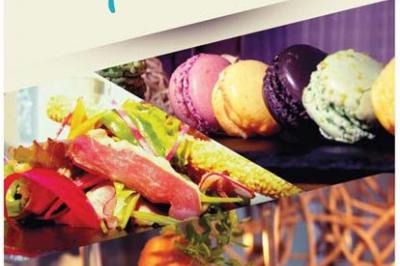 Plateaux de mets variés avec macarons colorés, salade fraîche et légumes cuisinés, présentés par un traiteur.