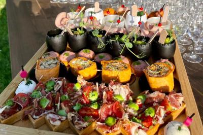 Plateau de bouchées apéritives variées avec charcuterie, légumes, verrines et décorations colorées.