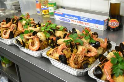 Plateaux de fruits de mer garnis de crevettes, moules, poissons et herbes fraîches, disposés sur un plan de travail en…