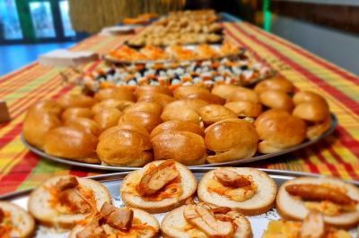 Plateaux de bouchées apéritives variées disposés sur une table recouverte d'une nappe colorée.